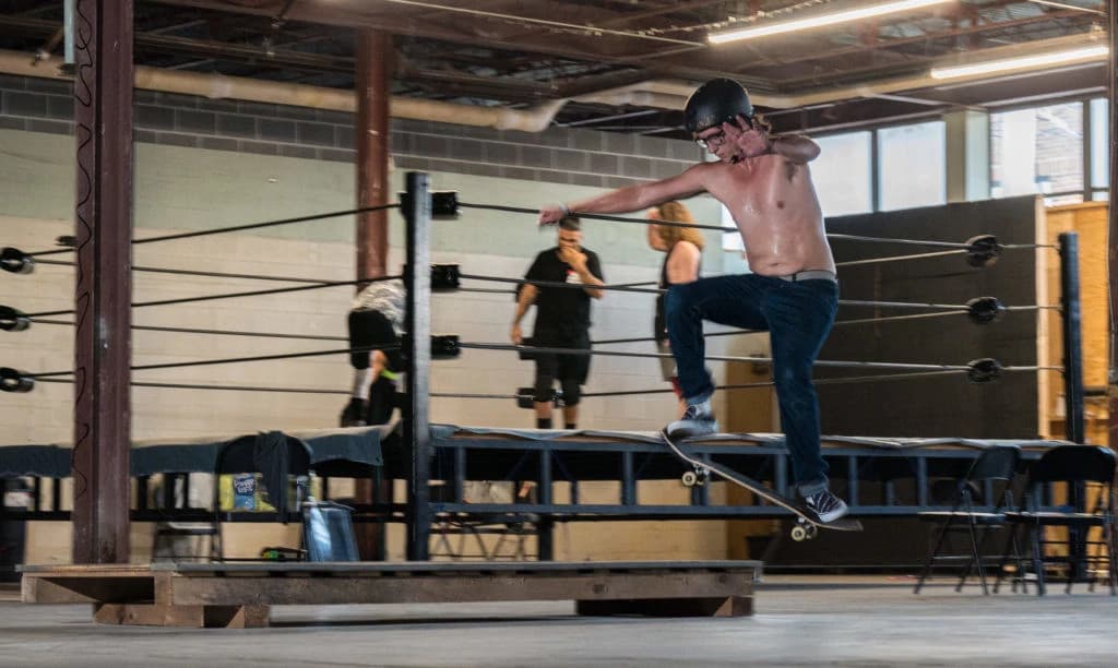 DJ performing live with headphones and sound mixer in a dark club atmosphere with purple and pink lighting