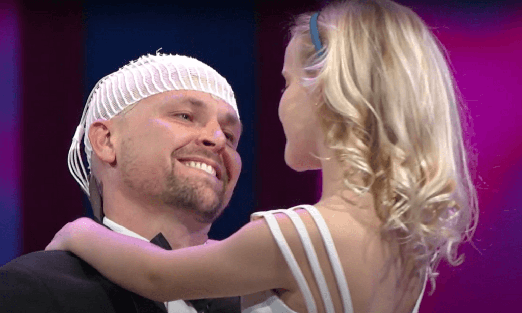 Portrait of Mike, a professional in a blue shirt, smiling confidently against a blue background
