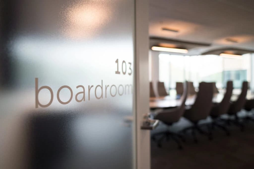 Professional business meeting in a modern boardroom with diverse executives discussing strategy