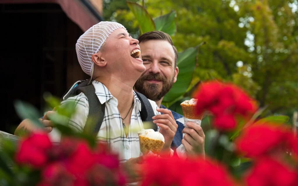 Portrait of confident young African American man smiling outdoors with city buildings in background