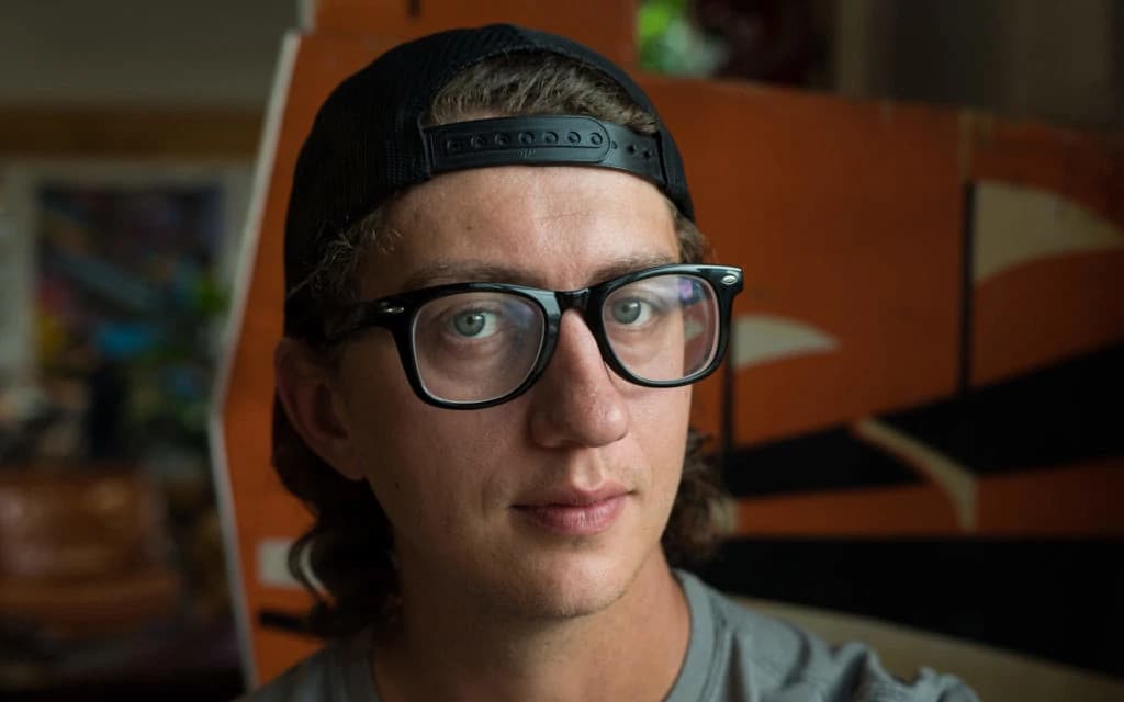 Portrait of Stewart, a professional Novocure employee, smiling in a modern office setting with a blurred background