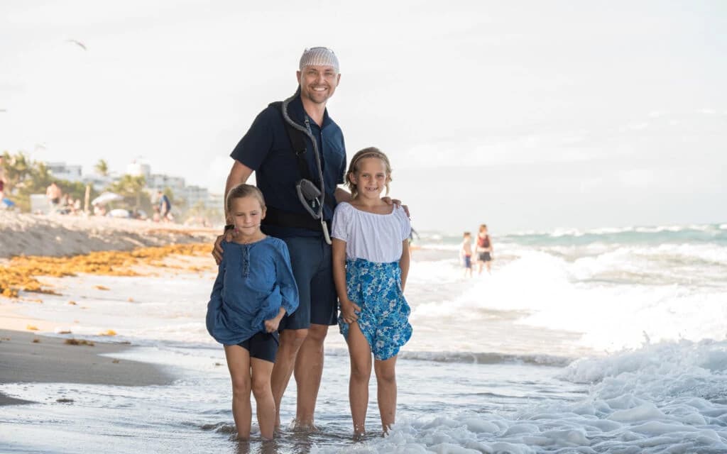 Portrait of a confident middle-aged man with beard wearing a gray shirt against a dark background