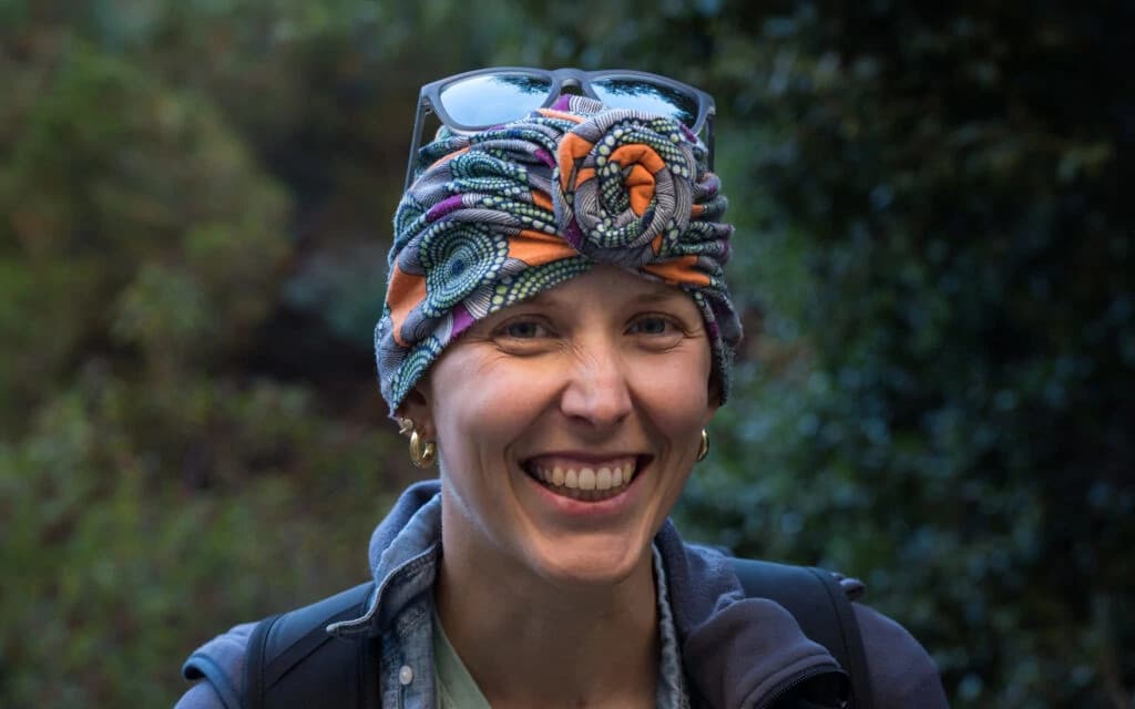 Professional portrait of Janice, a confident businesswoman with brown hair wearing a black blazer and a green top