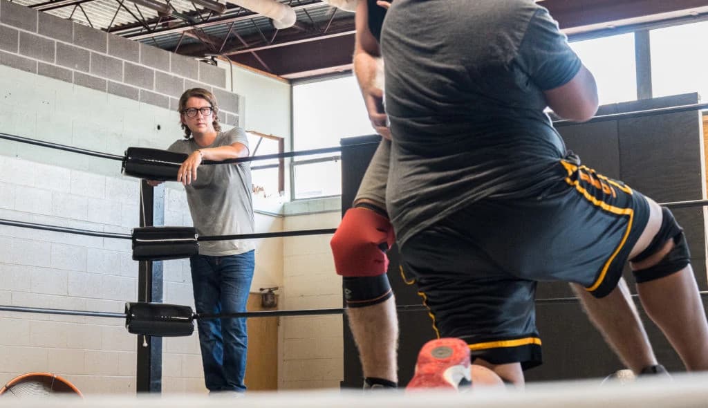 Professional man in glasses and suit using a laptop in a modern office with sunlight