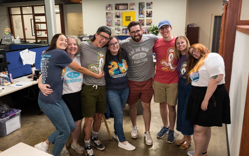 Three diverse healthcare professionals discussing patient data on a tablet in a modern medical environment