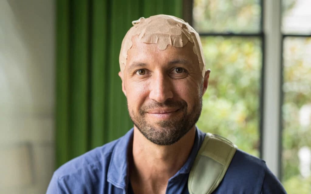 Smiling man named Kyle in a bright professional setting representing innovative cancer treatment solutions