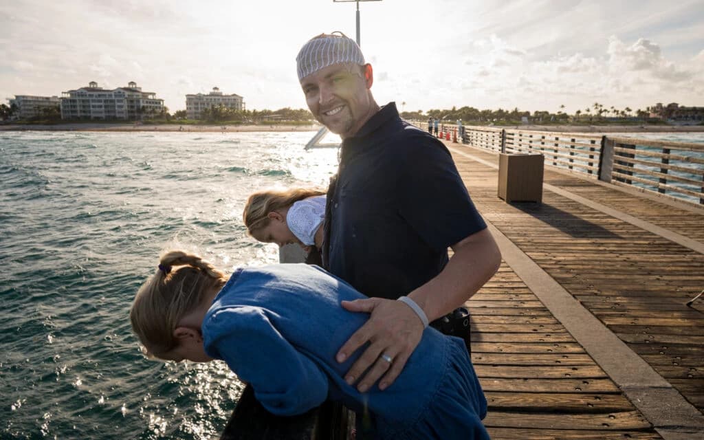 Professional portrait of Mike wearing a dark suit and light blue shirt smiling against a neutral background