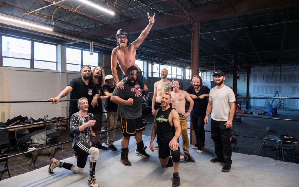 Young professional DJ performing with mixing console and laptop in a vibrant, neon-lit club environment